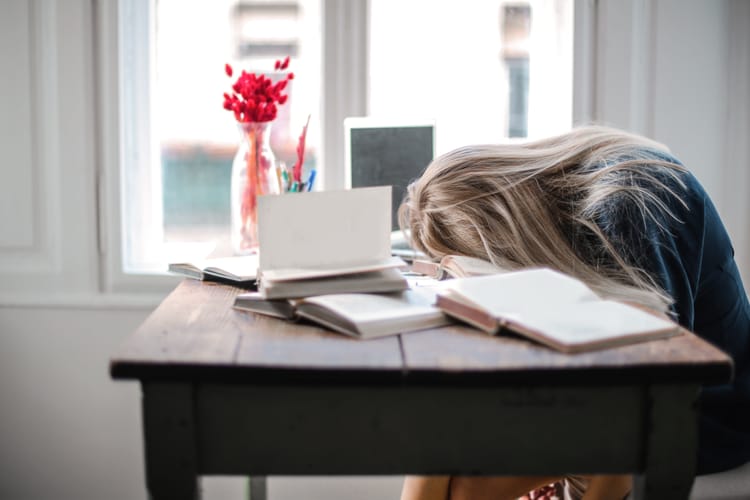 A woman slumped over her desk, not loving life